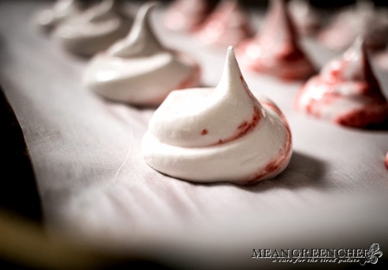 Strawberry Meringue Cookies piped onto a baking sheet lined with parchment paper.
