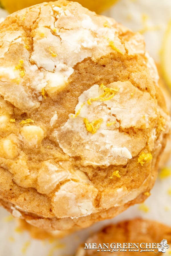 Close-up of a Meyer Lemon Crinkle Cookies with visible lemon zest and cracked sugar-coated top, showcasing its textured surface.