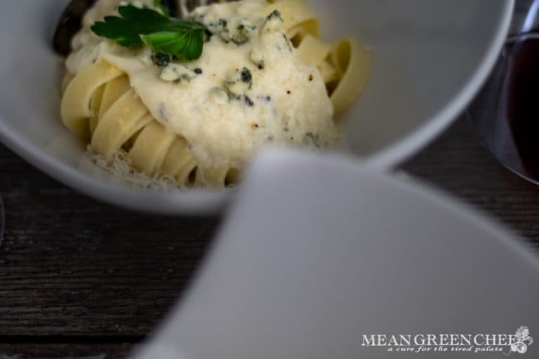 Pasta Alfredo in white bowls o a wooden background