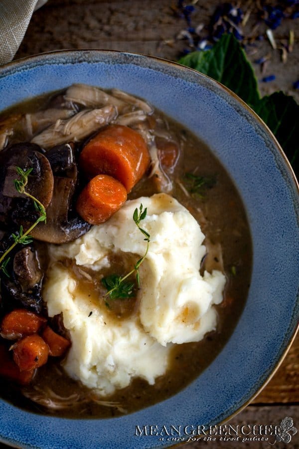 Coq Au Vin in a blue bowl on a wooden background