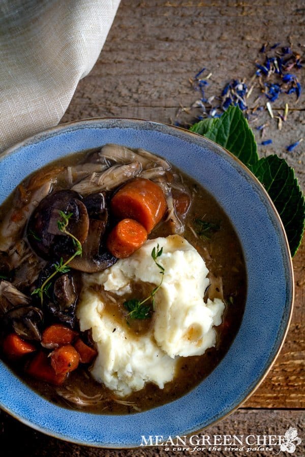 Coq Au Vin in a blue bowl on a wooden background