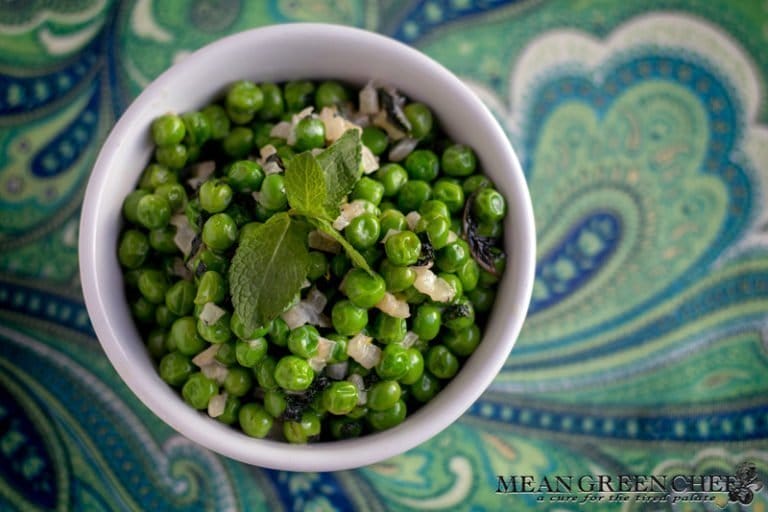 Minted Peas with Lemon and Shallots in a white bowl on a paisley background.
