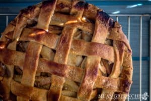 Caramel Apple Pie baked and cooling on a rack on a gray wooden background. Mean Green Chef