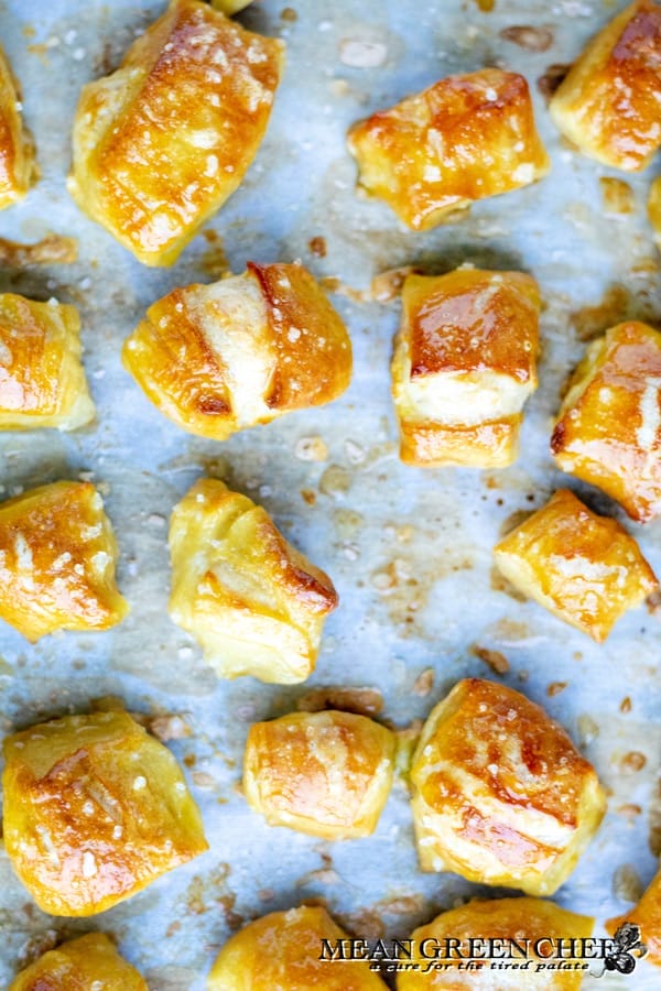 Soft Pretzel Bites after baking in the oven, golden brown. Situated on a parchment lined baking sheet.