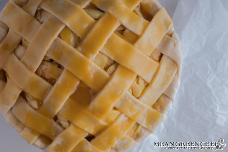 Overhead photo of Lattice Pie Crust over a caramel apple pie, photographed on a parchment paper background. Mean Green Chef