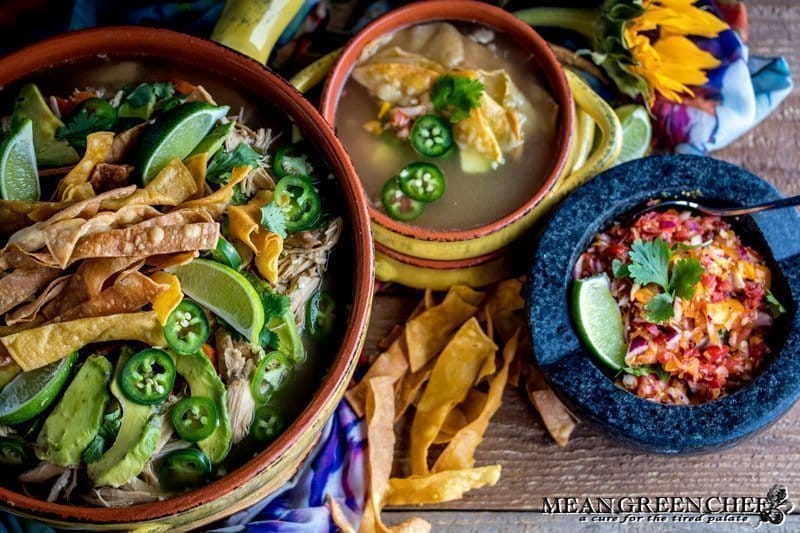 Overhead photo of Mexican Tortilla Chicken Soup Recipe in terracotta pot and bowls with crispy tortilla strips
