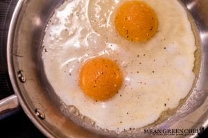 Sunny side up eggs cooking for Restaurant Style Corned Beef Hash.