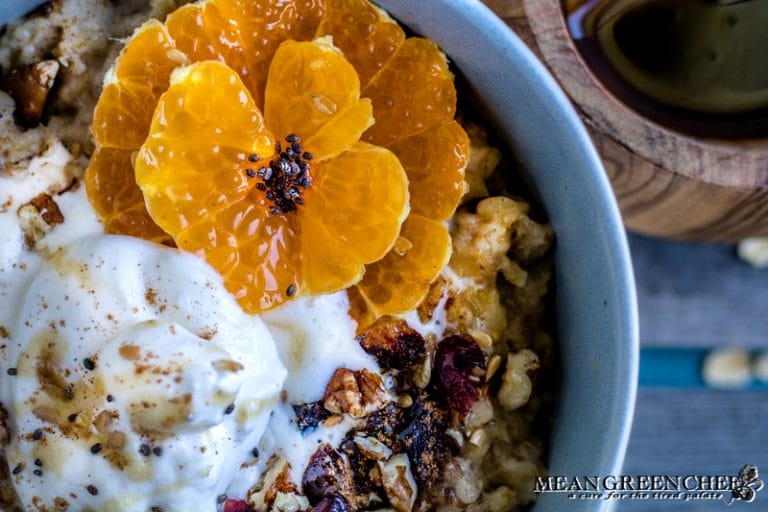 Overhead shot of a bowl of Spiced Mandarin Pecan Oatmeal garnished with whipped cream and Sumo Citrus.