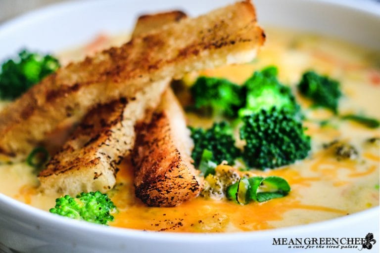 Close up of Bistro Broccoli Cheese Soup in large white bowl with grilled sourdough bread slices.
