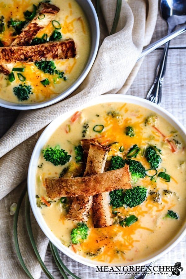 Bistro Broccoli Cheese Soup in large white bowls with grilled sourdough bread slices.