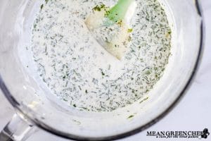 Herbed Buttermilk Ranch Dressing being mixed in a large glass bowl.