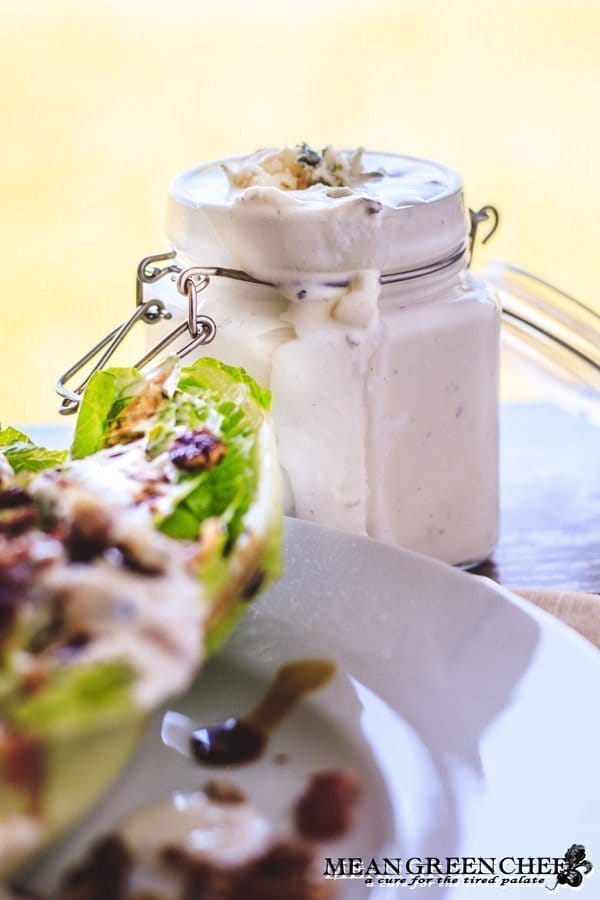 Buttermilk Blue Cheese Dressing in a glass jar next to a wedge salad.