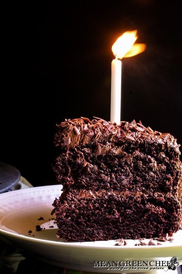 Slice of Chocolate Storm Cake with a glowing candle on top.
