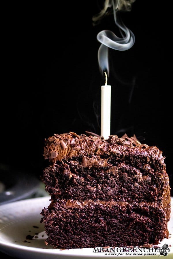 Slice of Chocolate Storm Cake with a candle that has just been blown out.