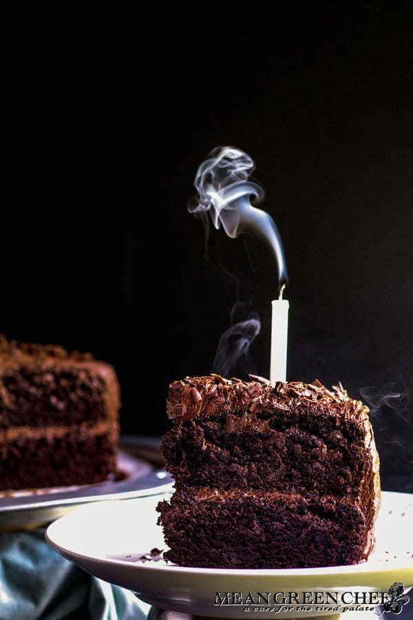 Slice of Chocolate Storm Cake with a candle that has just been blown out.