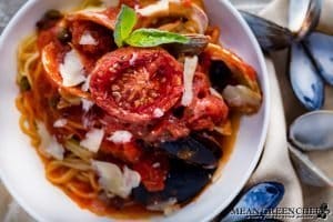 Bowl of Pasta Pescatore garnished with a sweet slow roasted tomato and fresh basil.