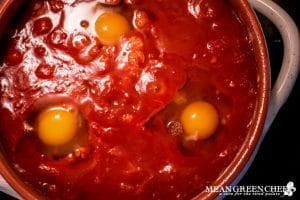 Eggs that are poaching in tomato sauce for Shakshuka.