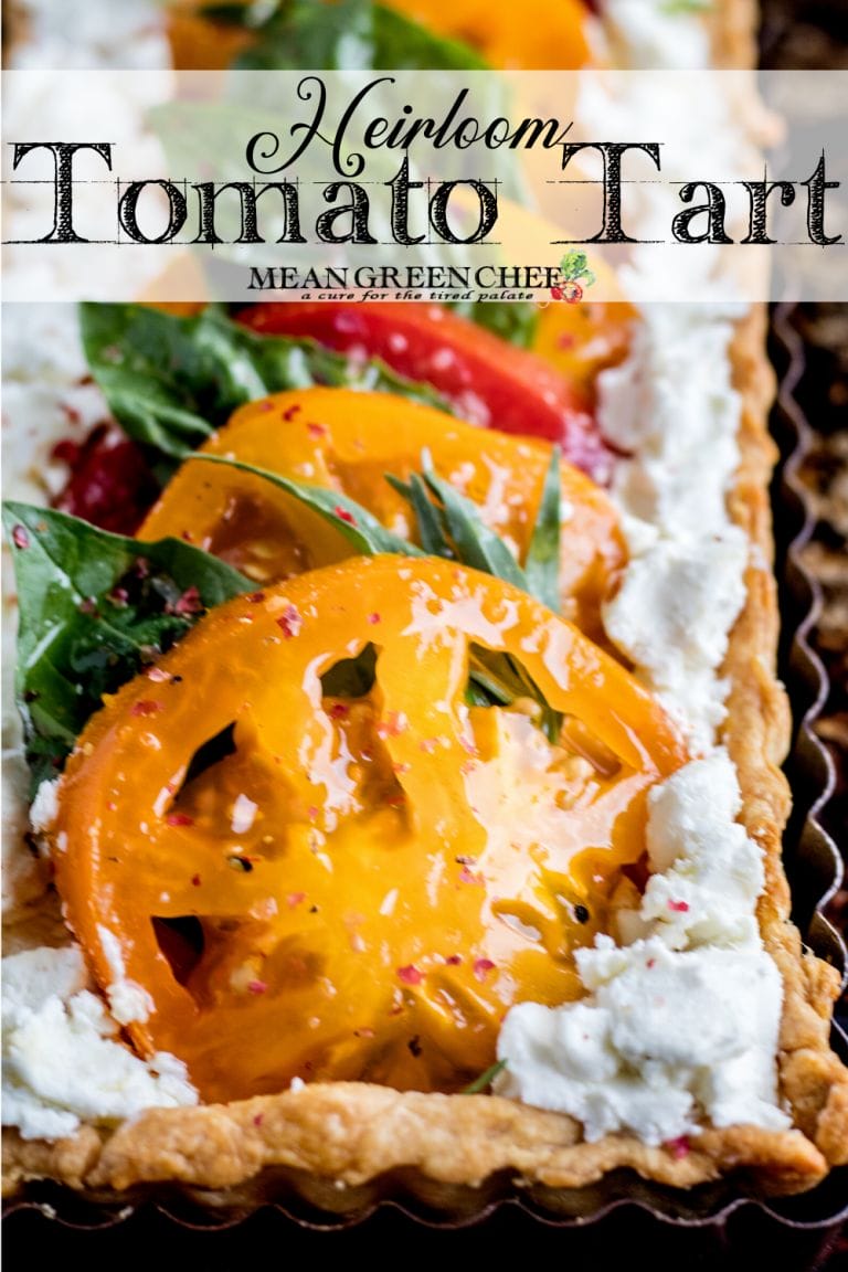 Heirloom Tomato Tart on a baking tray garnished with fresh basil.