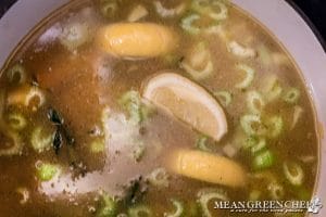 Broth and lemon added to ingredients to finish cooking Lemon Chicken Orzo Soup Recipe.