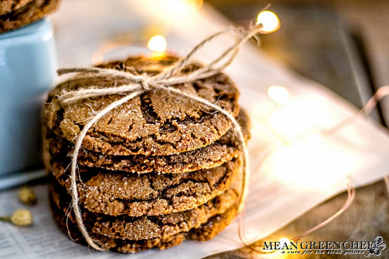 Stack of Molasses Cookies, tied with twine and sitting on newspaper that has been scattered with white flower buds