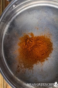 Toasting pumpkin pie spice and ground cinnamon in a pan.